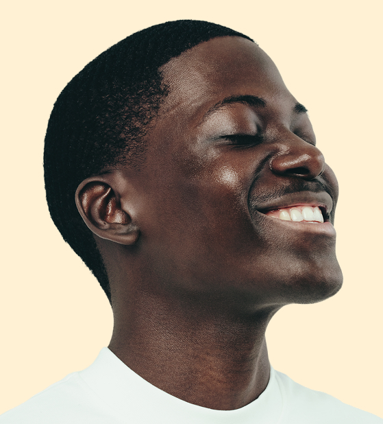 Young man with glowing skin and a photogenic satisfied smile against a yellow background