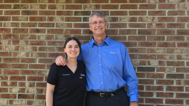 Dr. Joy with her arm around Dr. Vinson outside the orthodontics office